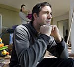 man frustrated with family in background